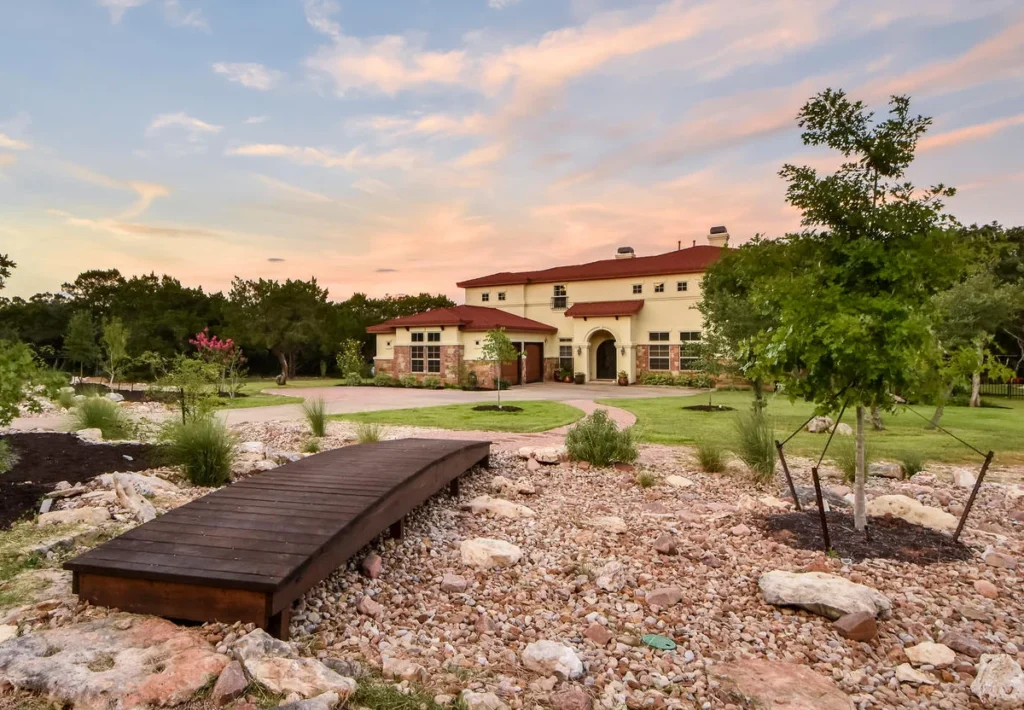 Landscaped yard featuring a bridge over a dry river bed