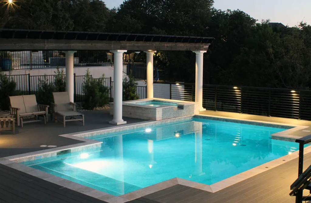 A custom in ground pool with hot rub and pergola