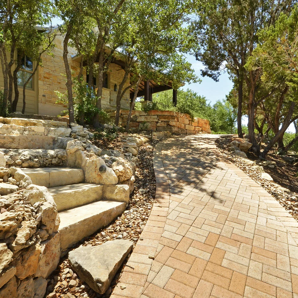a brick walkway through a landscaped Austin yard
