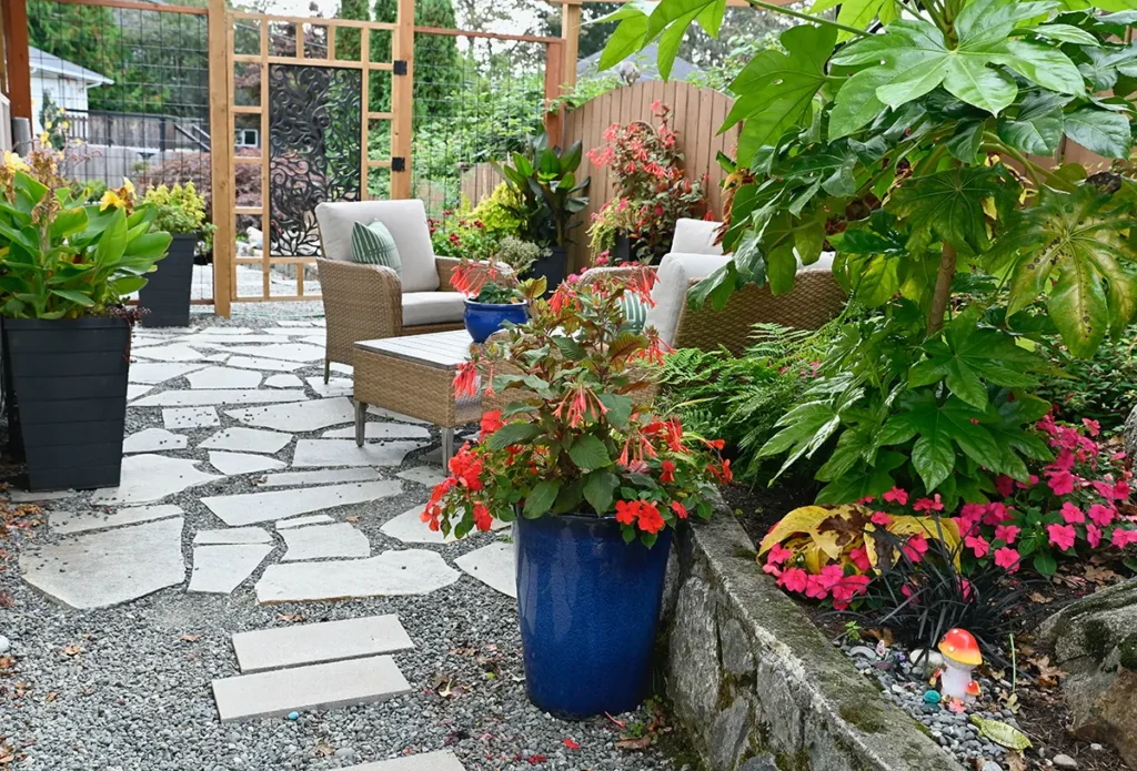 Modern xeriscaping that consists of a gravel and paver walkway, potted plants, and raised beds with a mix of vegetation.