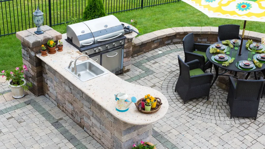 Outdoor kitchen and dining table on a paved patio